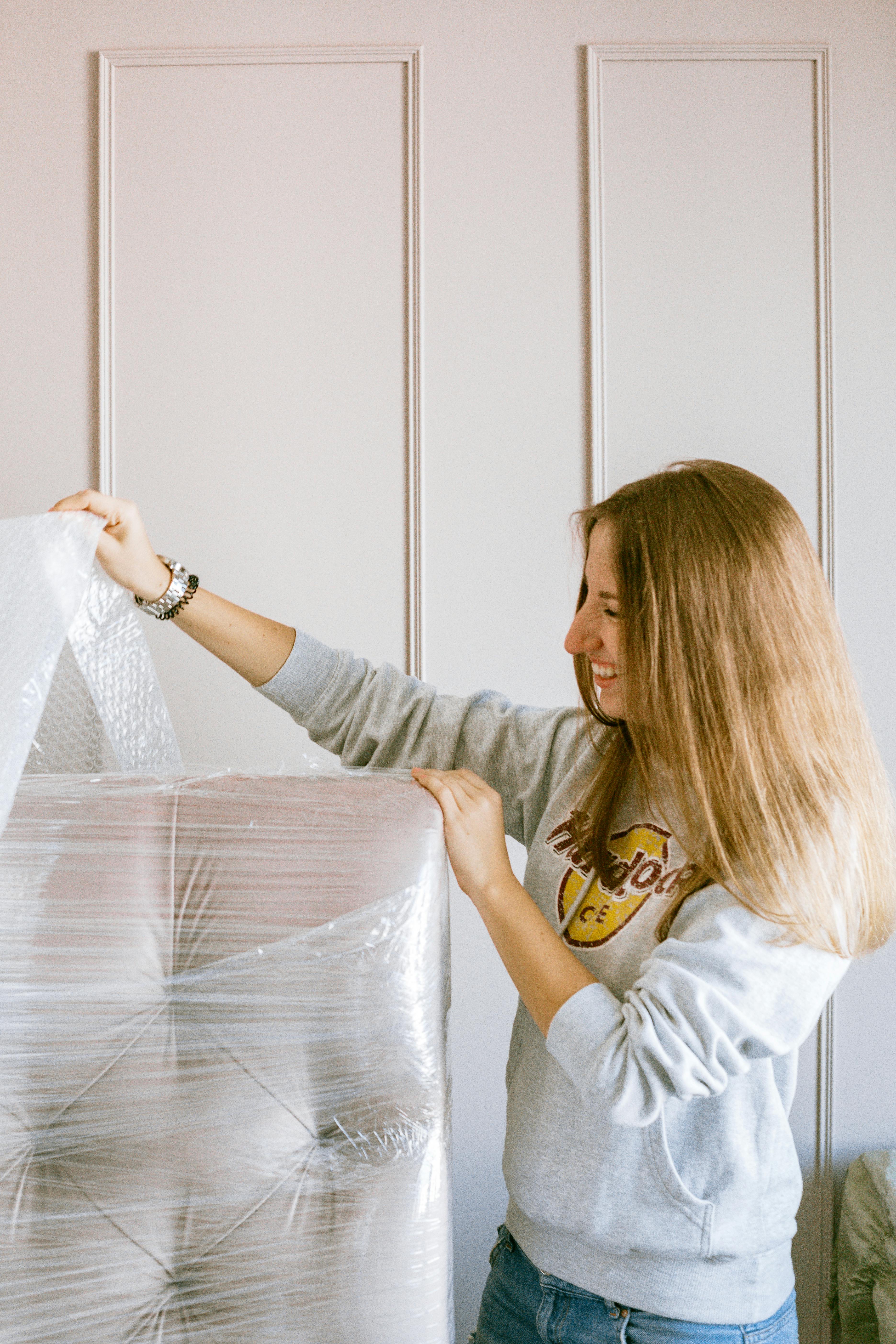Woman Removing The Plastic Wrap Of A Furniture Free Stock Photo