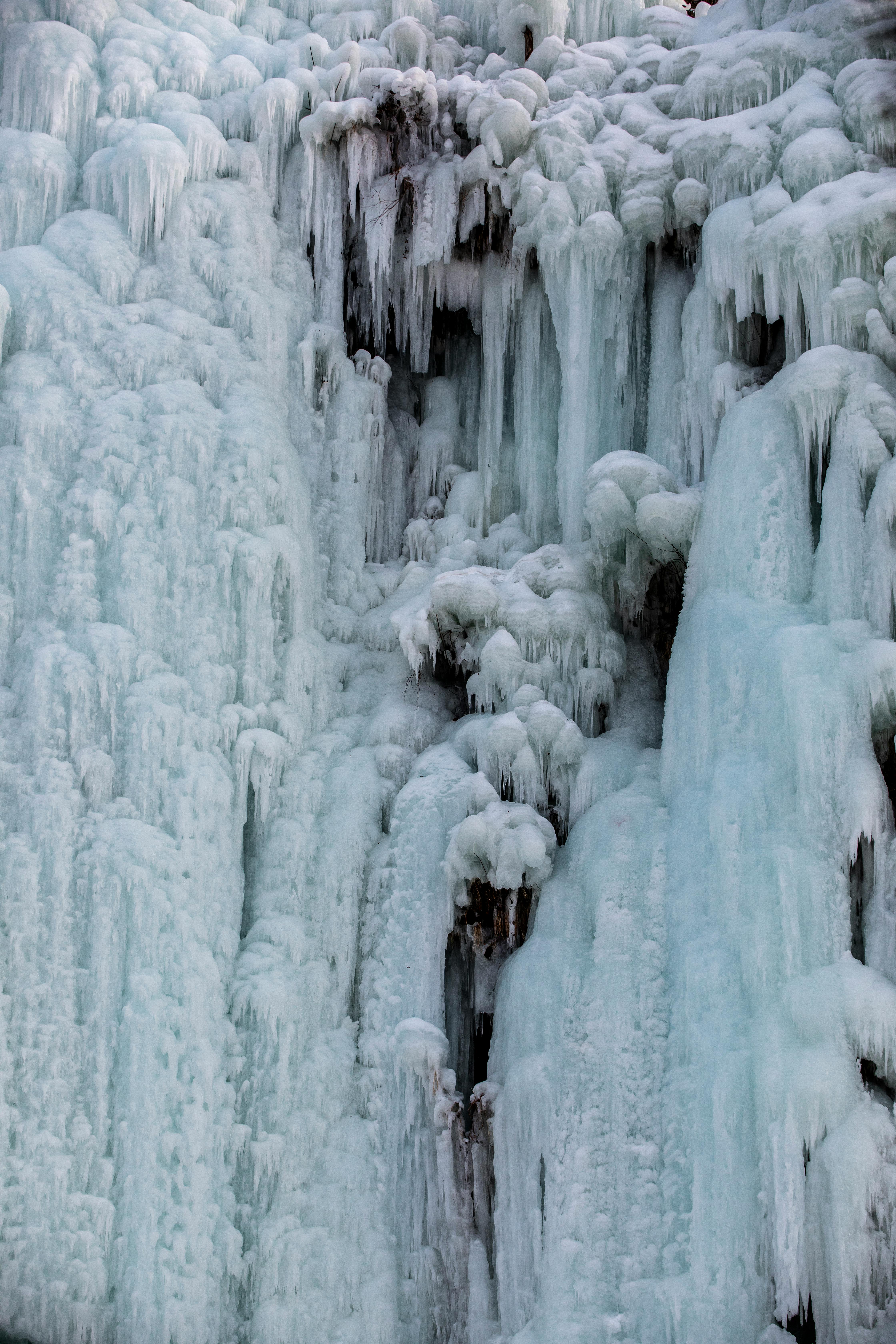 Stunning close-up of icy shapes on a frozen waterfall in winter.
