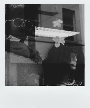 一张复古即时照片中，透过玻璃窗，展示了店内陈列着人体模型的时尚店面