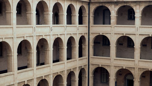 Elegant arched architecture in historic Marseille courtyard. Baroque style, warm tones, French design.