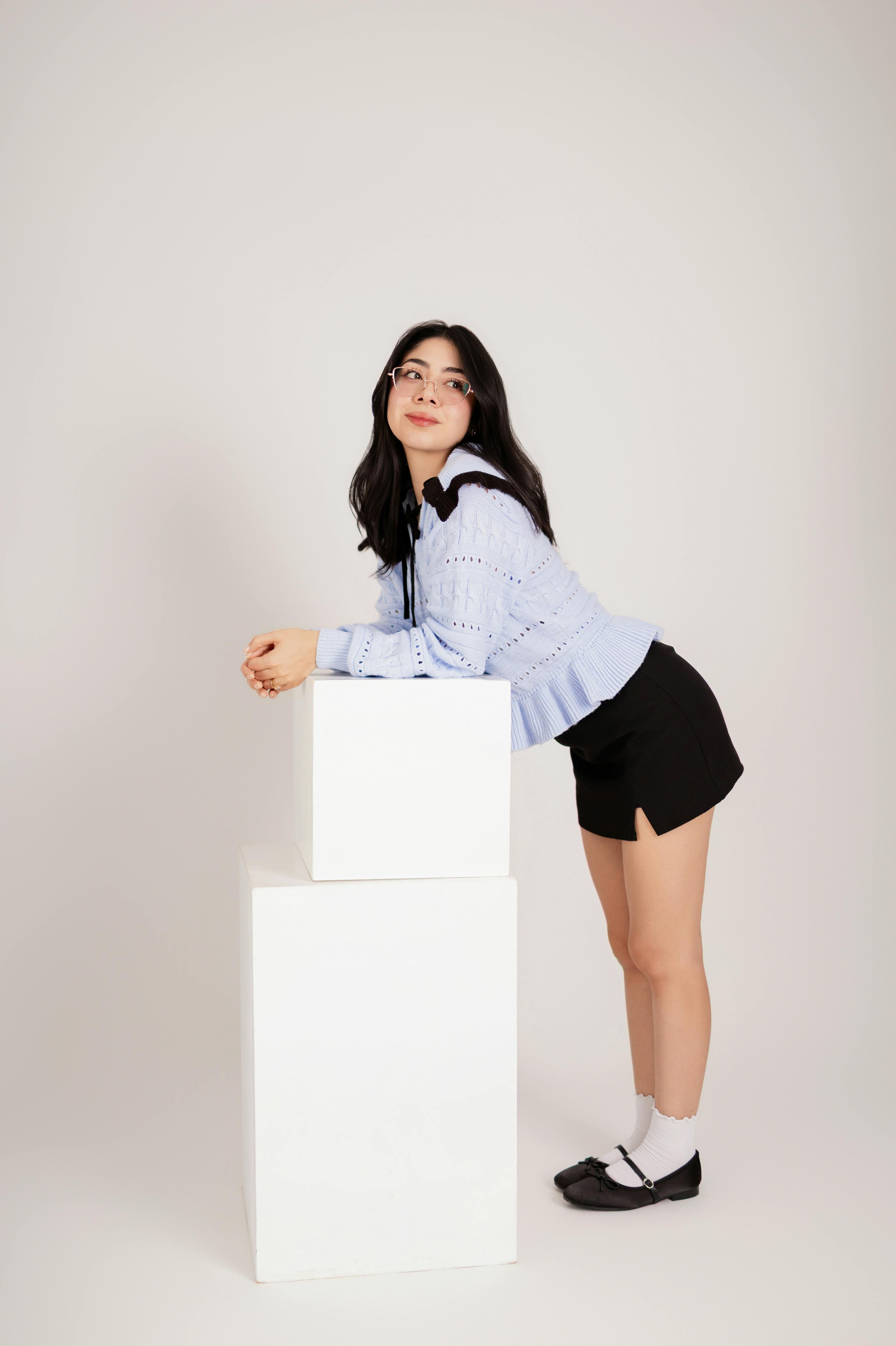 Gratis Ritratto di una donna con una camicetta azzurra e pantaloncini neri in posa creativa. Foto a disposizione