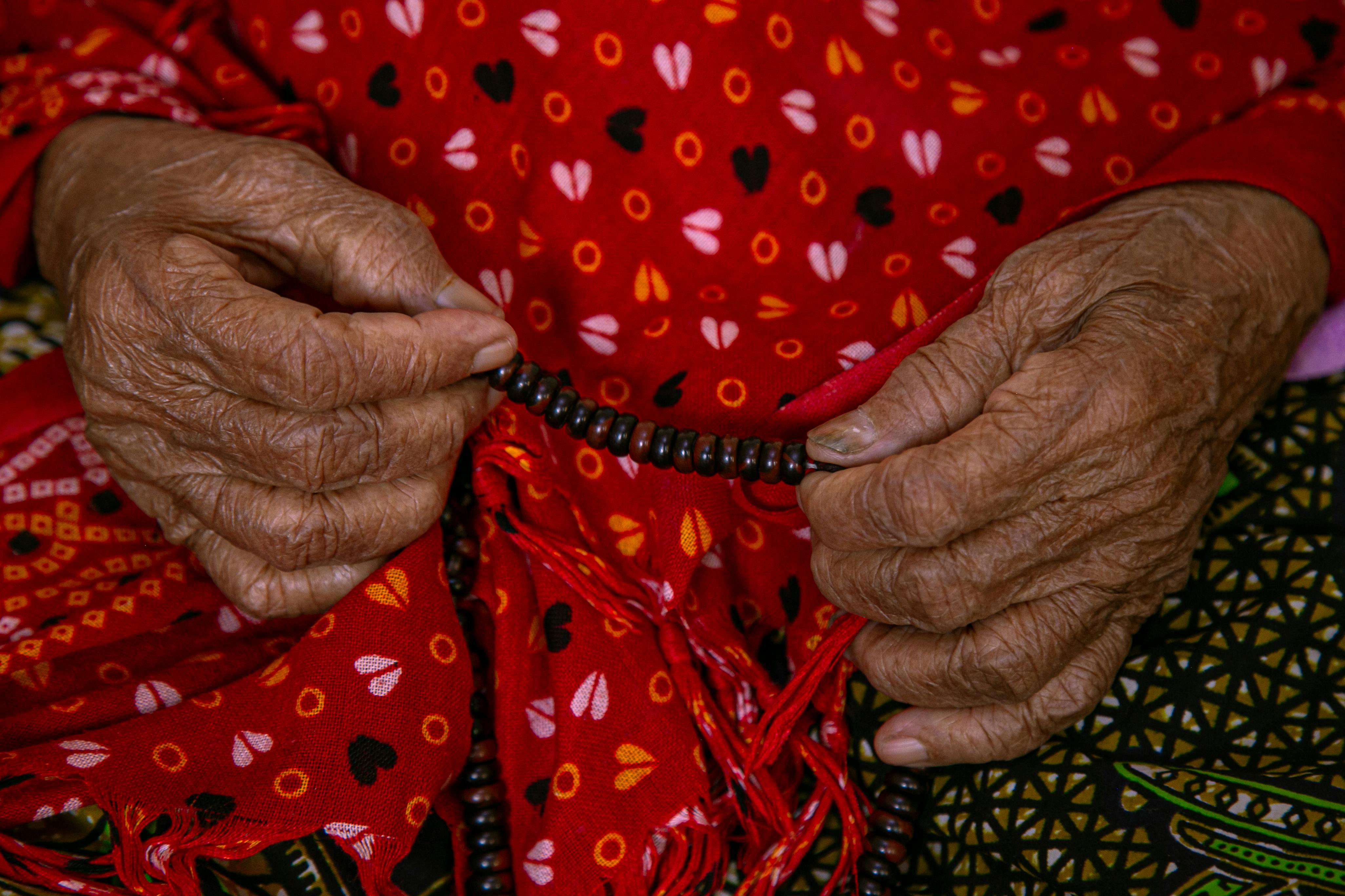 무료 염주를 쥐고 있는 노인의 손이 클로즈업되어 있다. 이는 영성과 문화를 상징한다. 스톡 사진