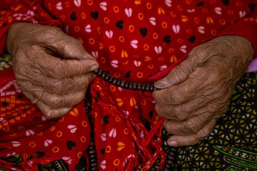 Free Close-up of senior hands holding prayer beads, symbolizing spirituality and culture. Stock Photo