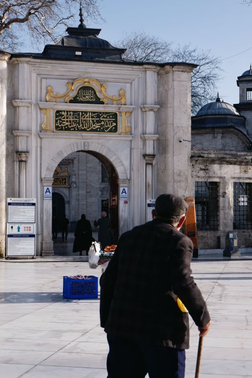 Free A pedestrian walks towards a historical archway in Istanbul, showcasing traditional architecture. Stock Photo