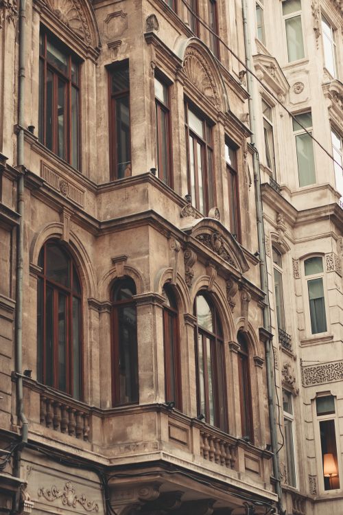 Free Detailed facade of an old urban building with classic architectural design and ornate windows. Stock Photo