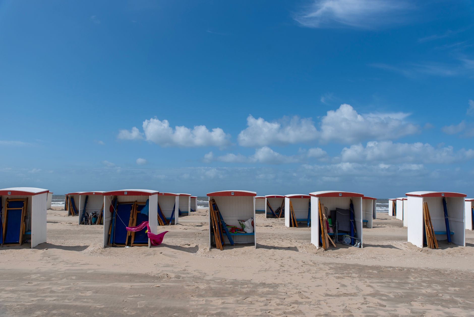 Row of colorful beach cabins on a sunny day at Katwijk aan Zee, Netherlands.