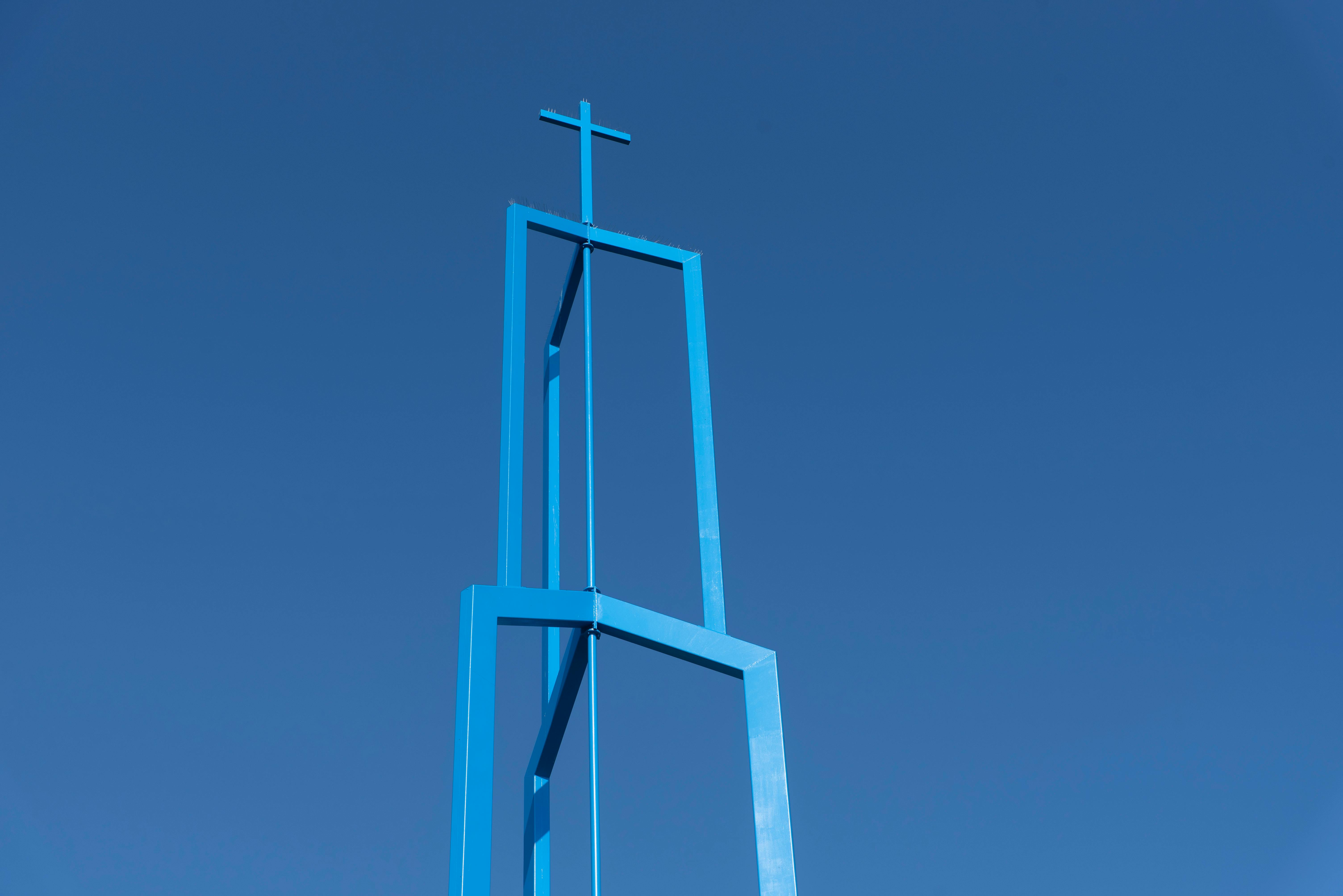 Gratis Et minimalistisk blått kirketårn med kors mot en klar blå himmel i Giessenburg, Nederland. Arkivbilde