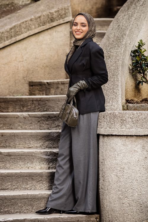 Free Elegant woman in formal attire on stone staircase, showcasing modern style outdoors. Stock Photo
