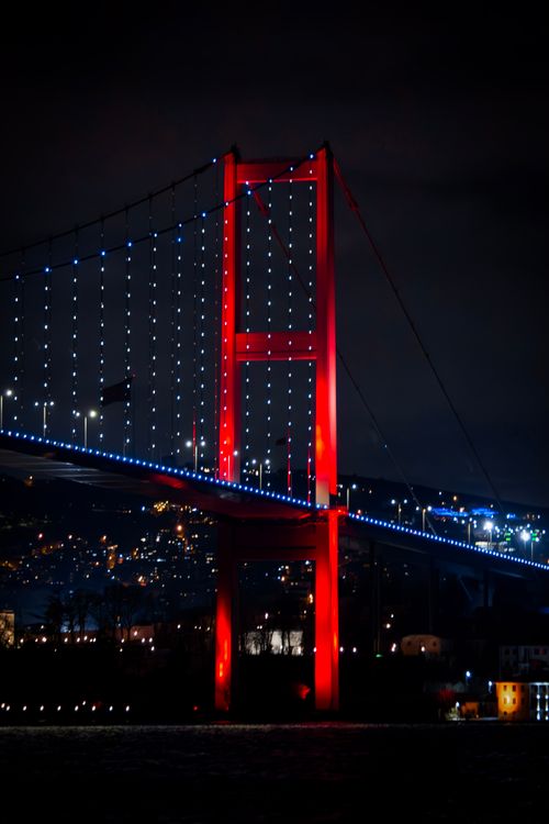 Free Stunning night view of Bosphorus Bridge in İstanbul glowing with vibrant red and blue lights. Stock Photo