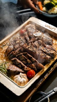 Deliciously grilled steak served hot with vegetables, steam rising.