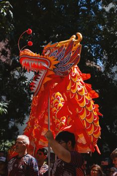Vibrant Chinese dragon dance during daytime festival in Buenos Aires.