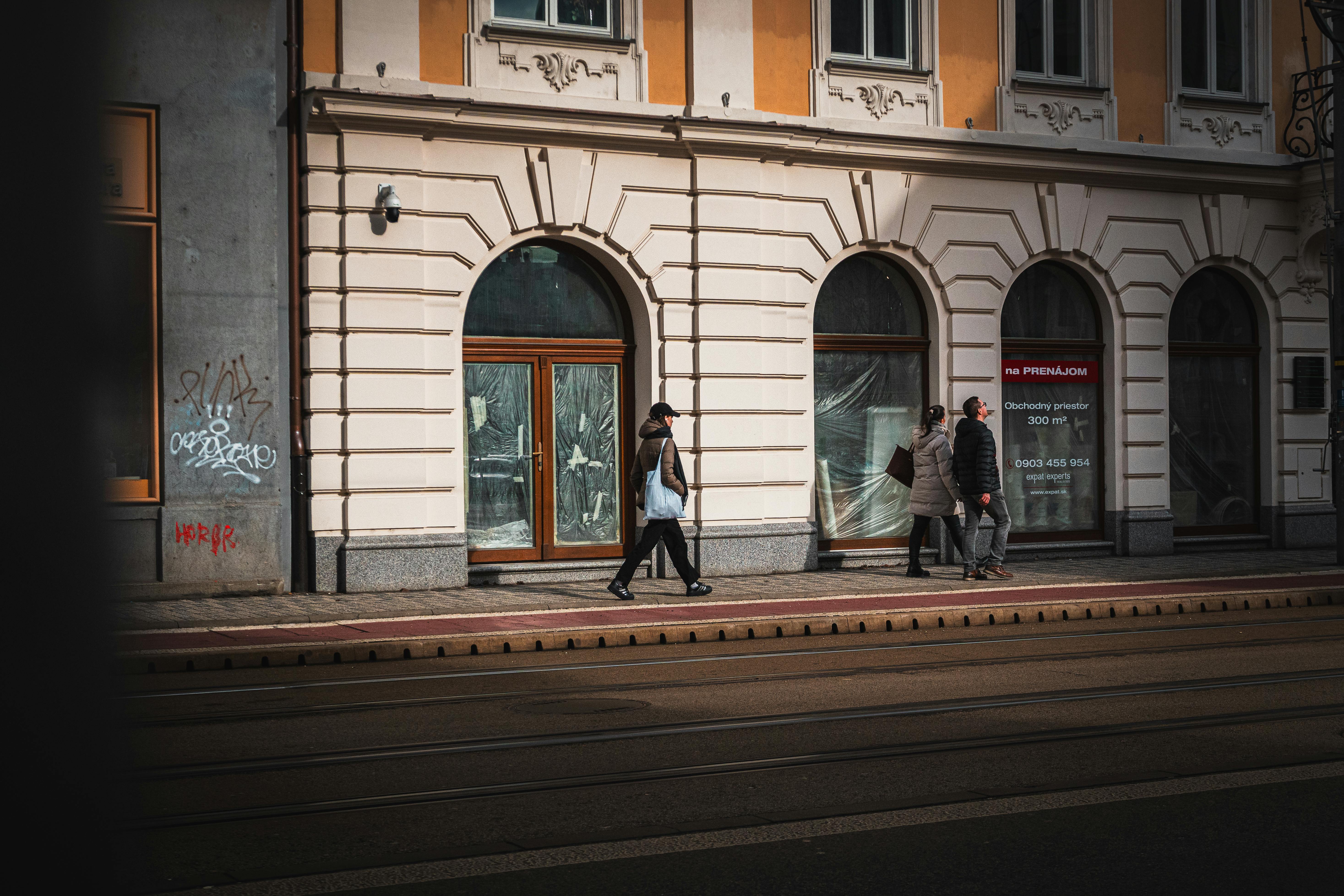 Ücretsiz Tarihi binaların önünden geçen yayalarla dolu, hareketli bir sokak manzarası. Stok Fotoğraflar