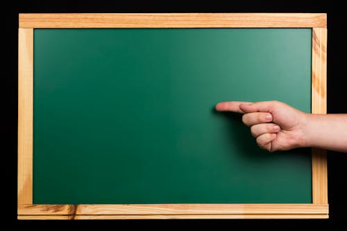 Free Persons Hand on Green Board Stock Photo