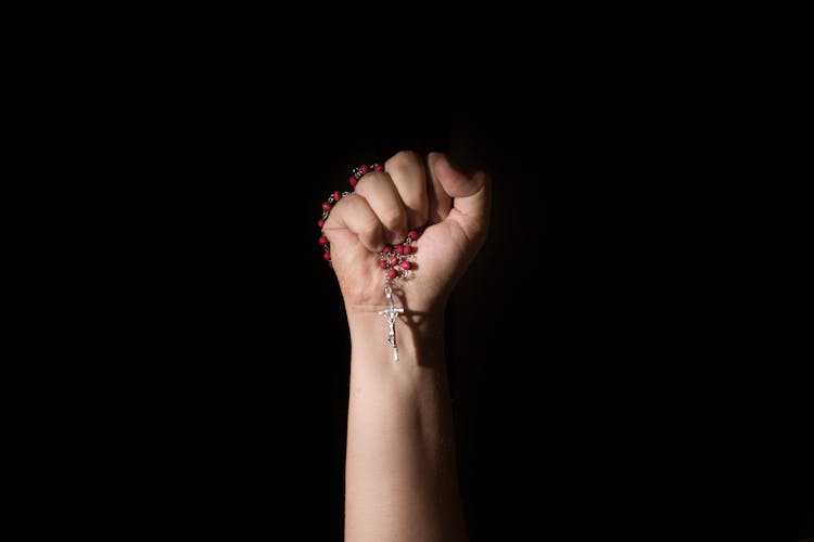 Person Holding A Rosary