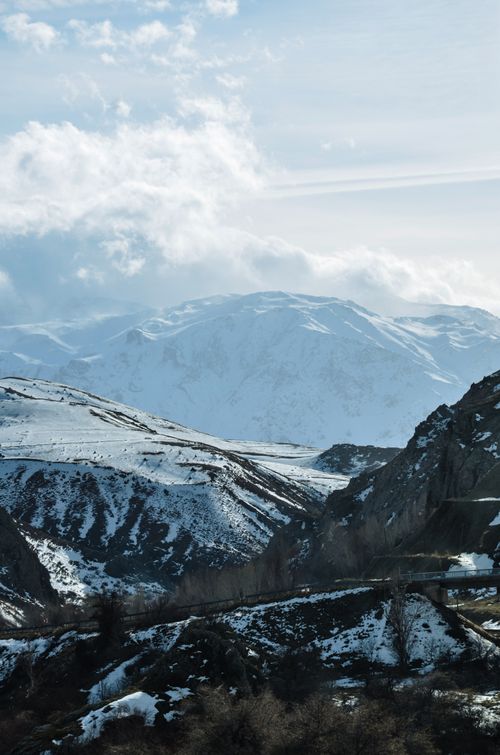 Free Majestic snow-covered mountain range under a cloudy winter sky. Stock Photo