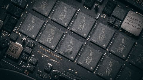 Detailed view of electronic circuit board components showcasing microchips and technology intricacies.