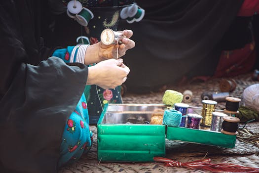 A woman organizes colorful sewing threads and tools in a box, crafting at home.
