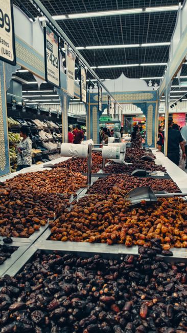 Selection of different dates on display at an indoor market. Busy shopping environment with signs. - Recognizing Red Flags in Online Stores