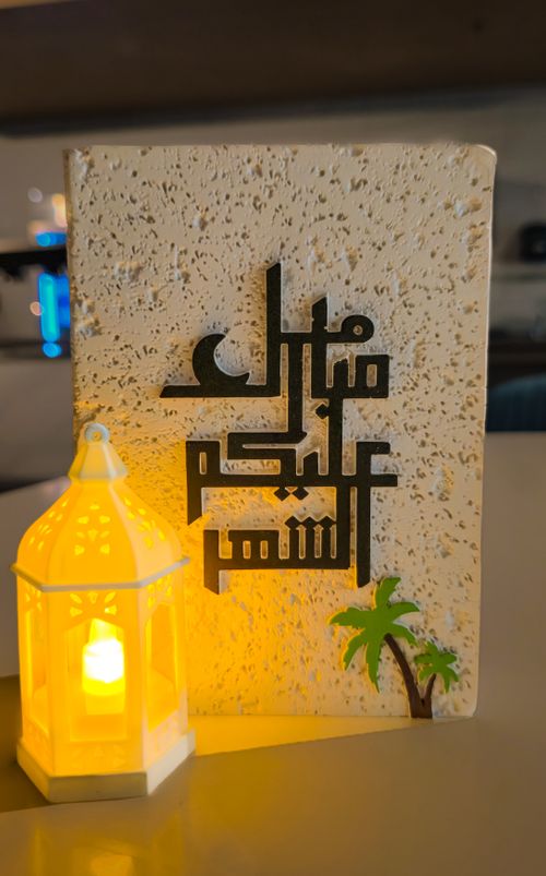 Free Elegant Arabic calligraphy artwork with a glowing lantern, evoking cultural warmth. Stock Photo