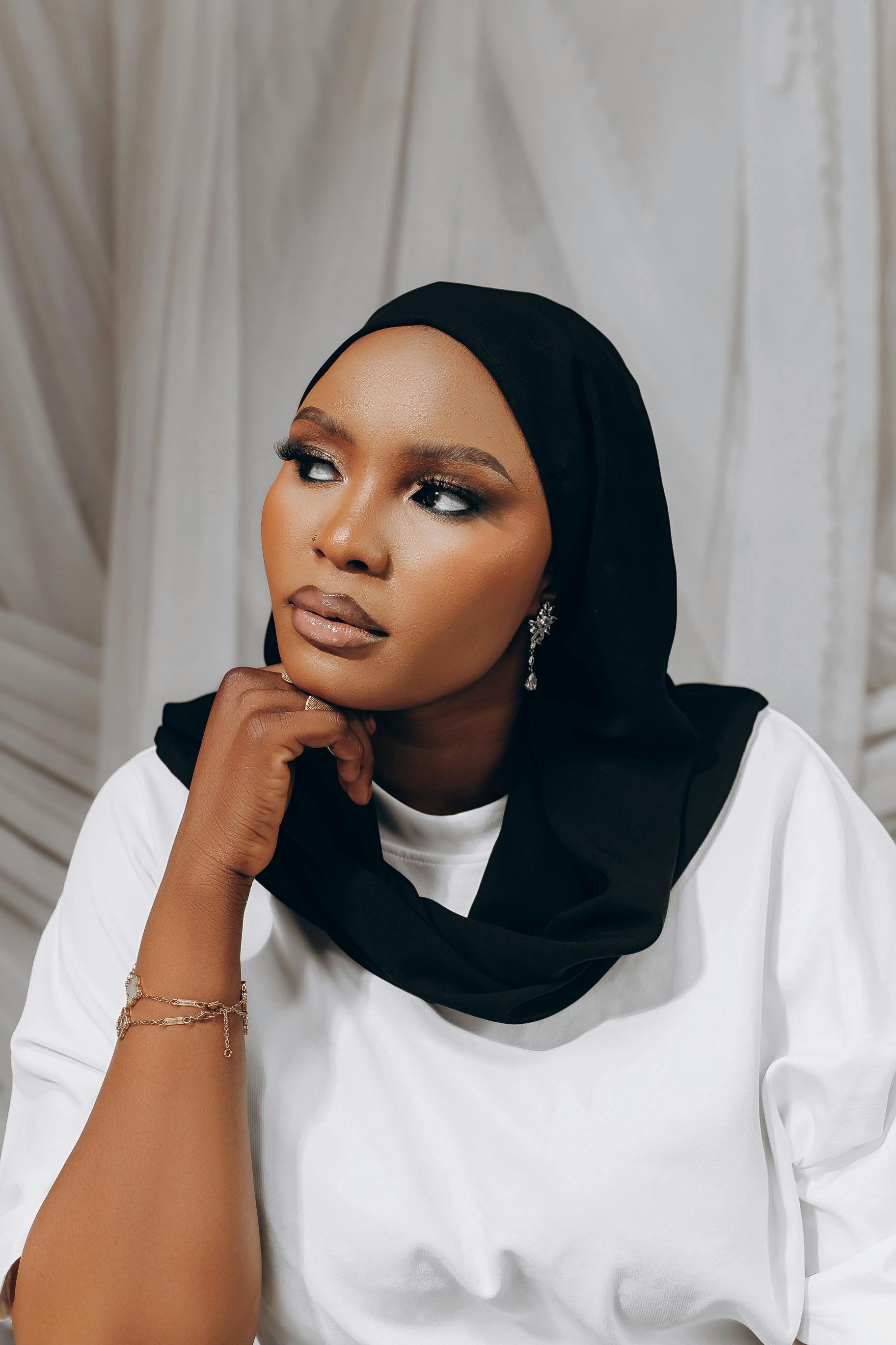 ฟรี ภาพถ่ายระยะใกล้ของหญิงสาวผู้สง่างามสวมฮิญาบ กำลังครุ่นคิดอะไรบางอย่าง คลังภาพถ่าย