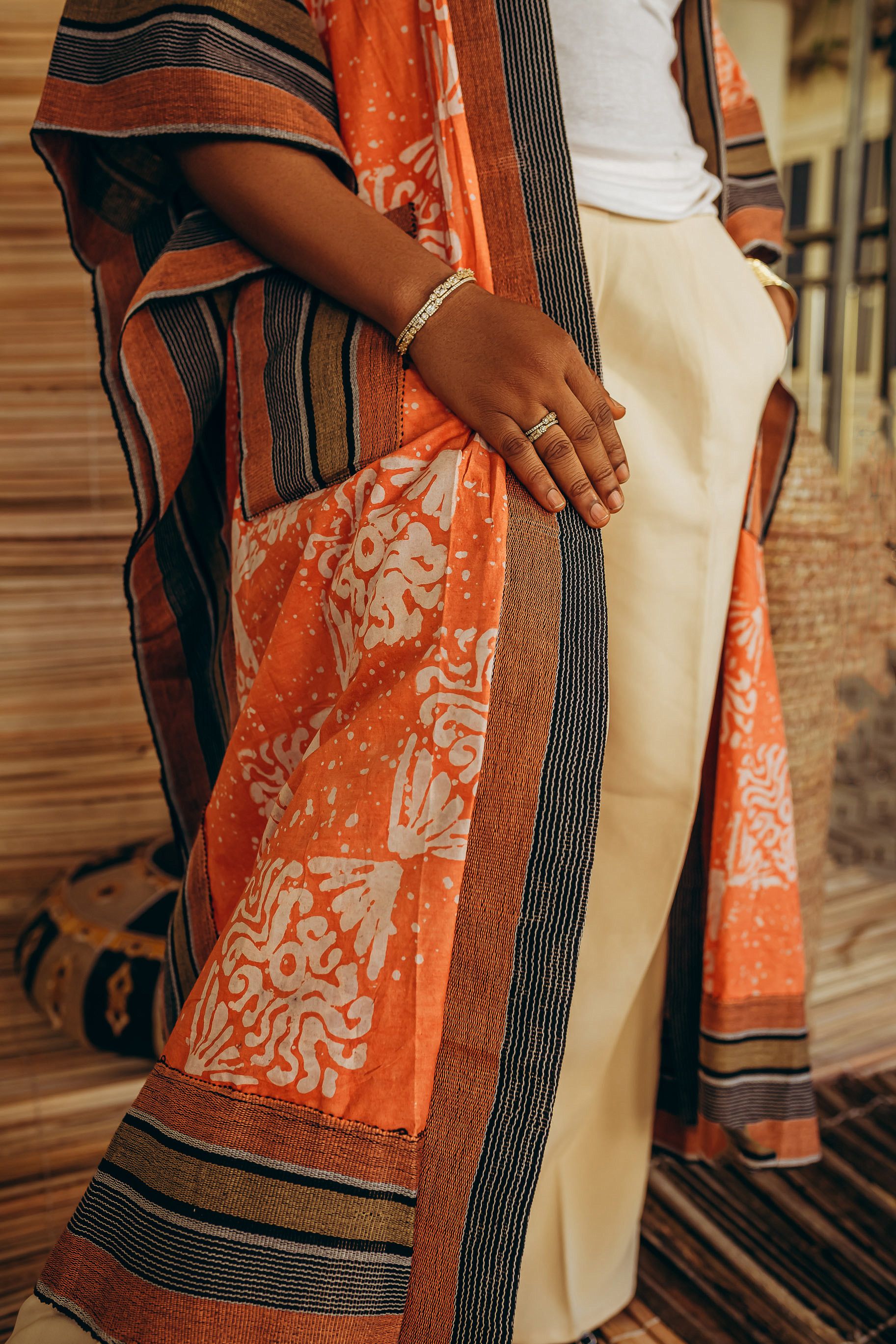 Robe elegante de inspiração africana em um vibrante tom de laranja com padrões e listras intrincados.