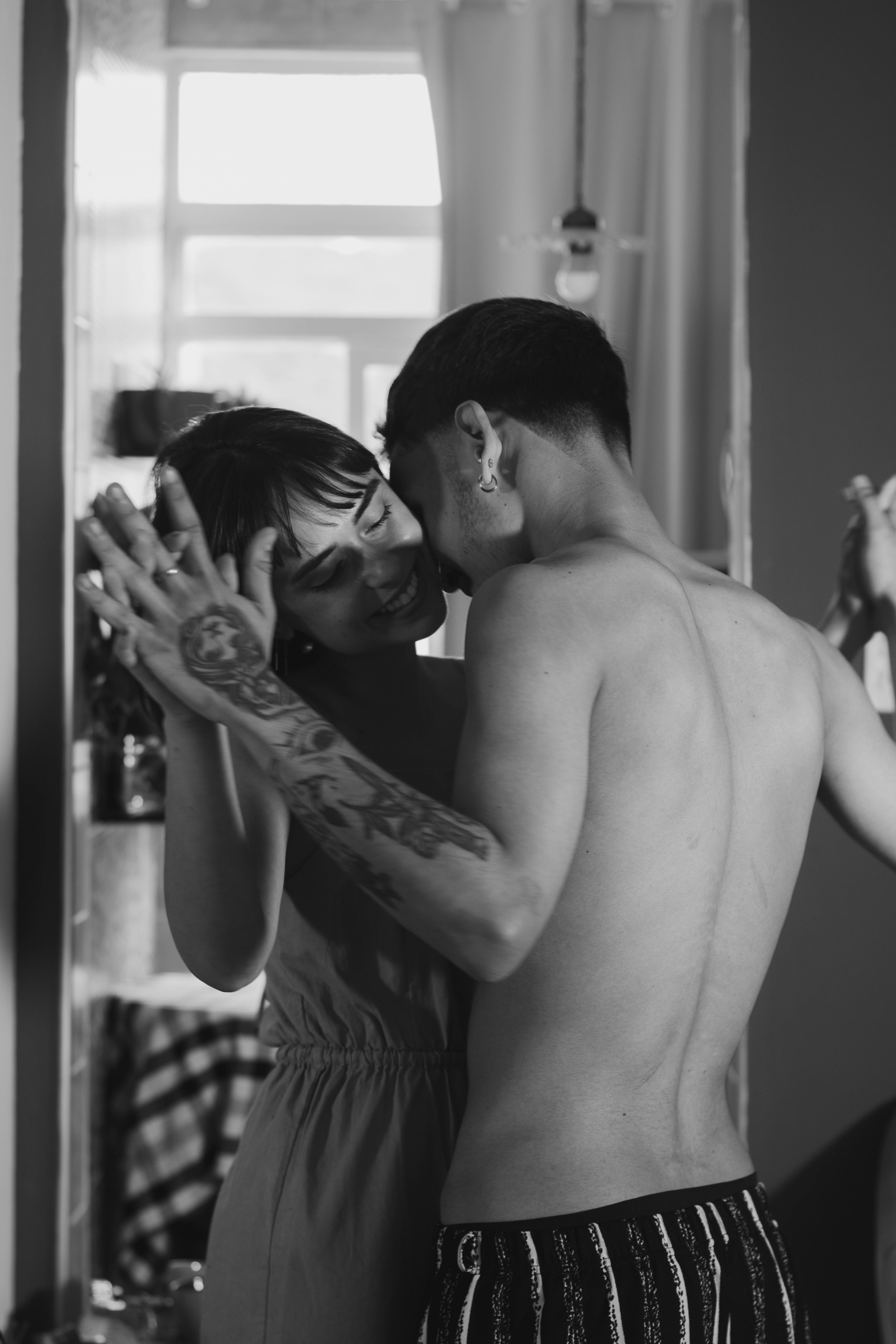 bezplatná Romantická černobílá fotografie páru sdílejícího intimní chvilku uvnitř. Základová fotografie