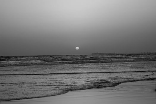 Monochrome sunset view over the ocean at Karachi beach, capturing tranquility and beauty.