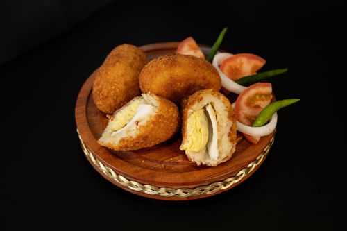 Free Golden fried egg chops served with fresh tomatoes and green chilies. Stock Photo