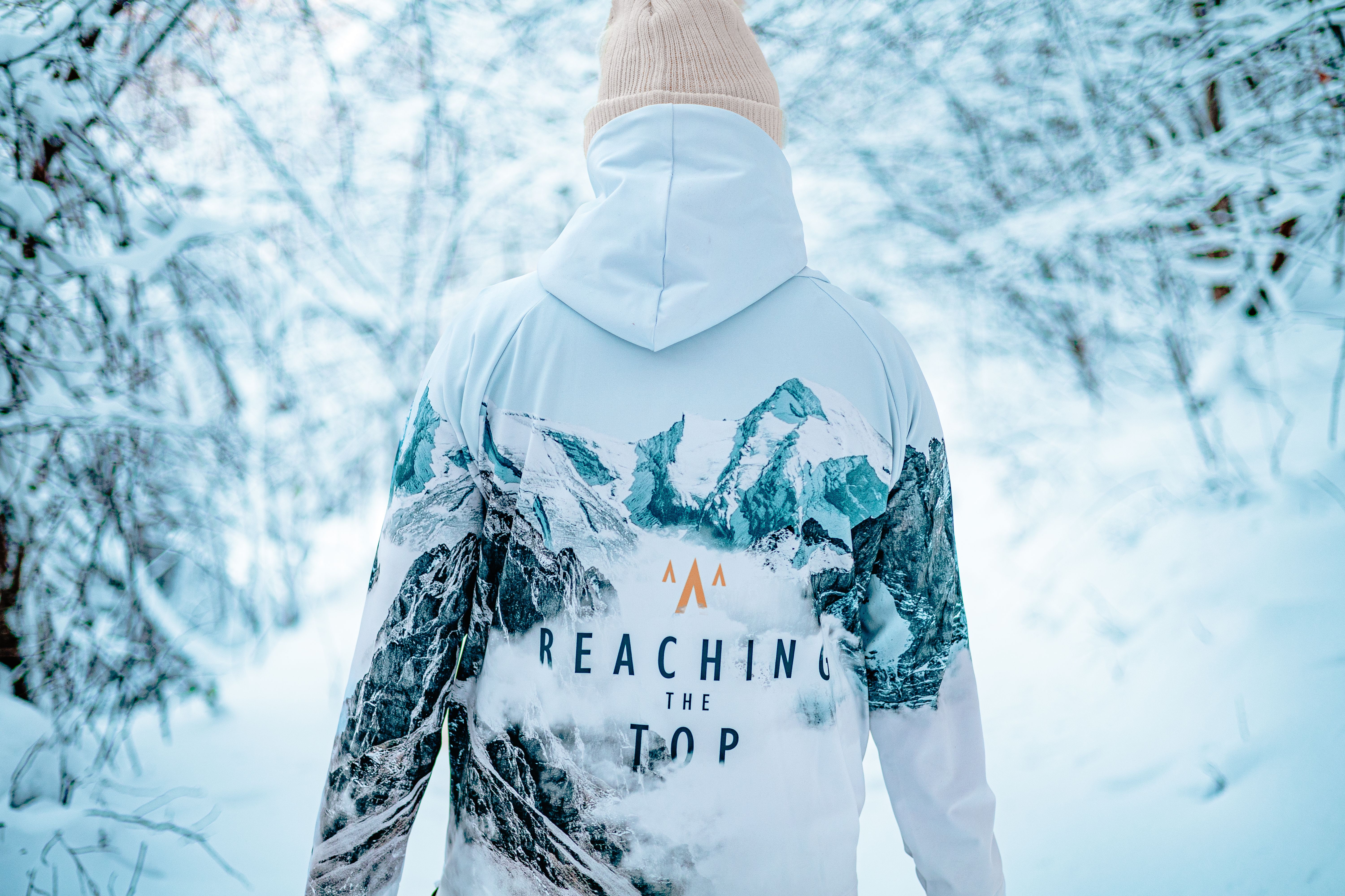 A person in a winter jacket hiking through a snowy forest, showcasing a sense of adventure.