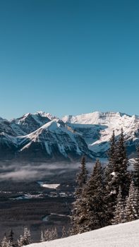 Stunning winter landscape at Lake Louise, Alberta, showcasing majestic snow-covered mountains and clear blue skies.
