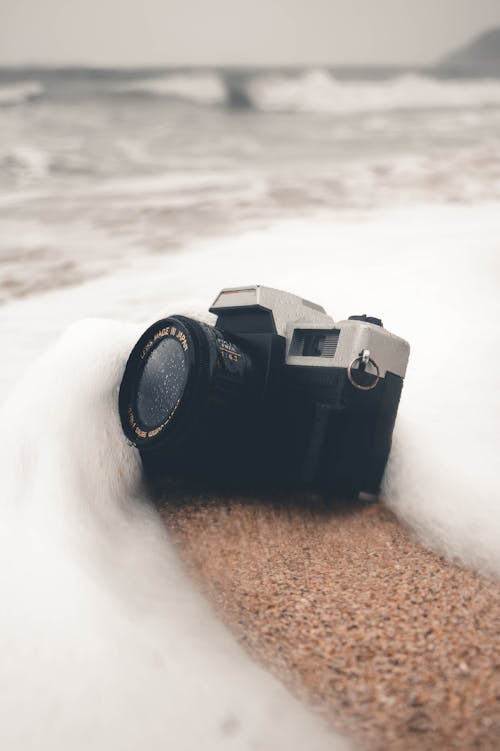茶色の砂の上の黒いカメラ