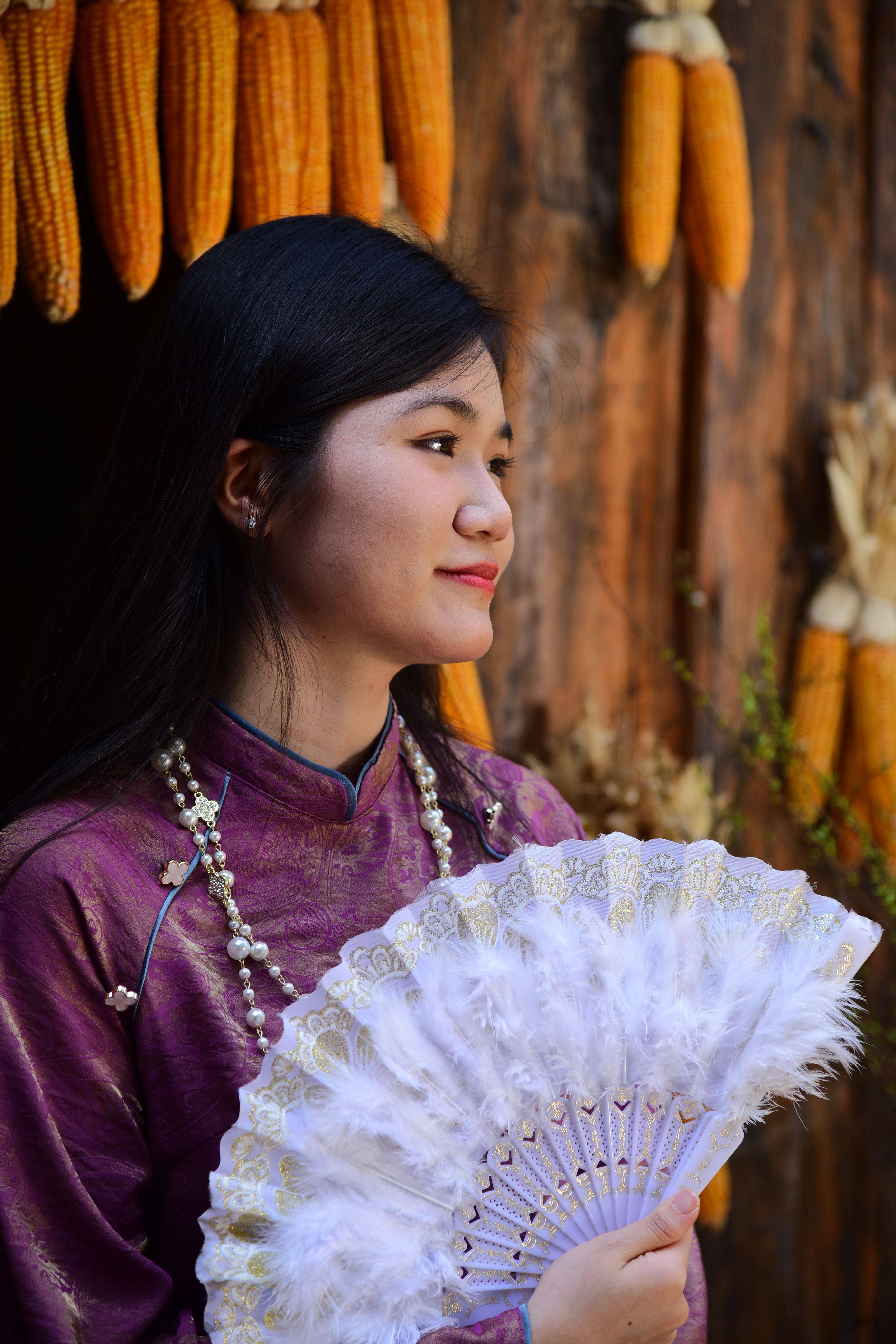 Portrait of a Woman with Traditional Fan and Corn Decor · Free Stock Photo