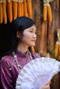 Woman in Traditional Dress Holding a Fan