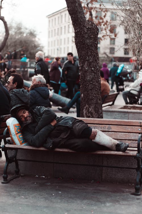 Photo of Man Lying on Wooden Bench