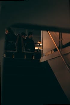 Dimly lit interior of a cruise ship with passengers sitting during night travel.
