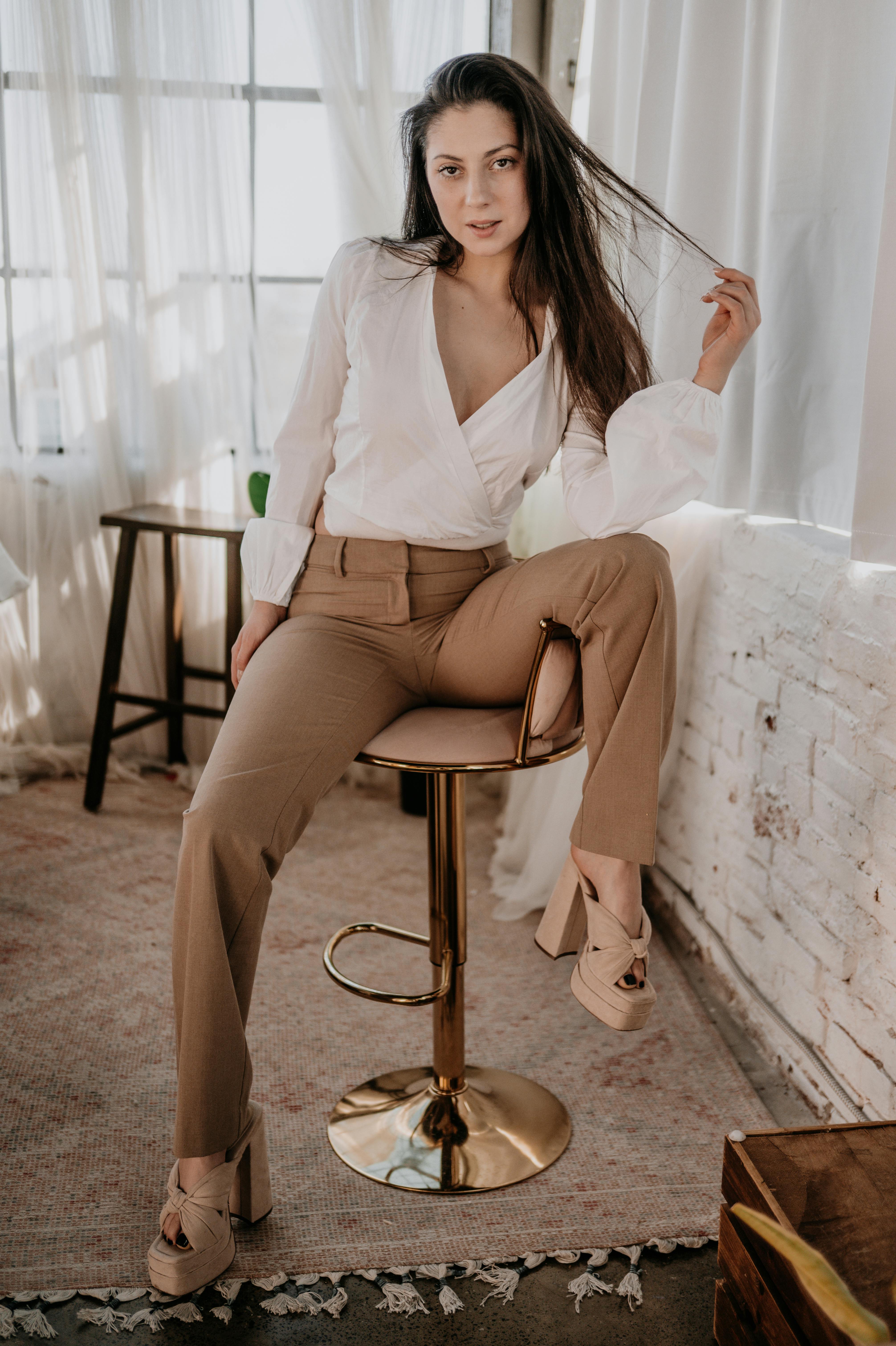 ฟรี หญิงสาวมั่นใจในชุดเก๋ไก๋โพสท่าในห้องใต้หลังคาใจกลางเมืองที่แสงแดดส่องถึง คลังภาพถ่าย