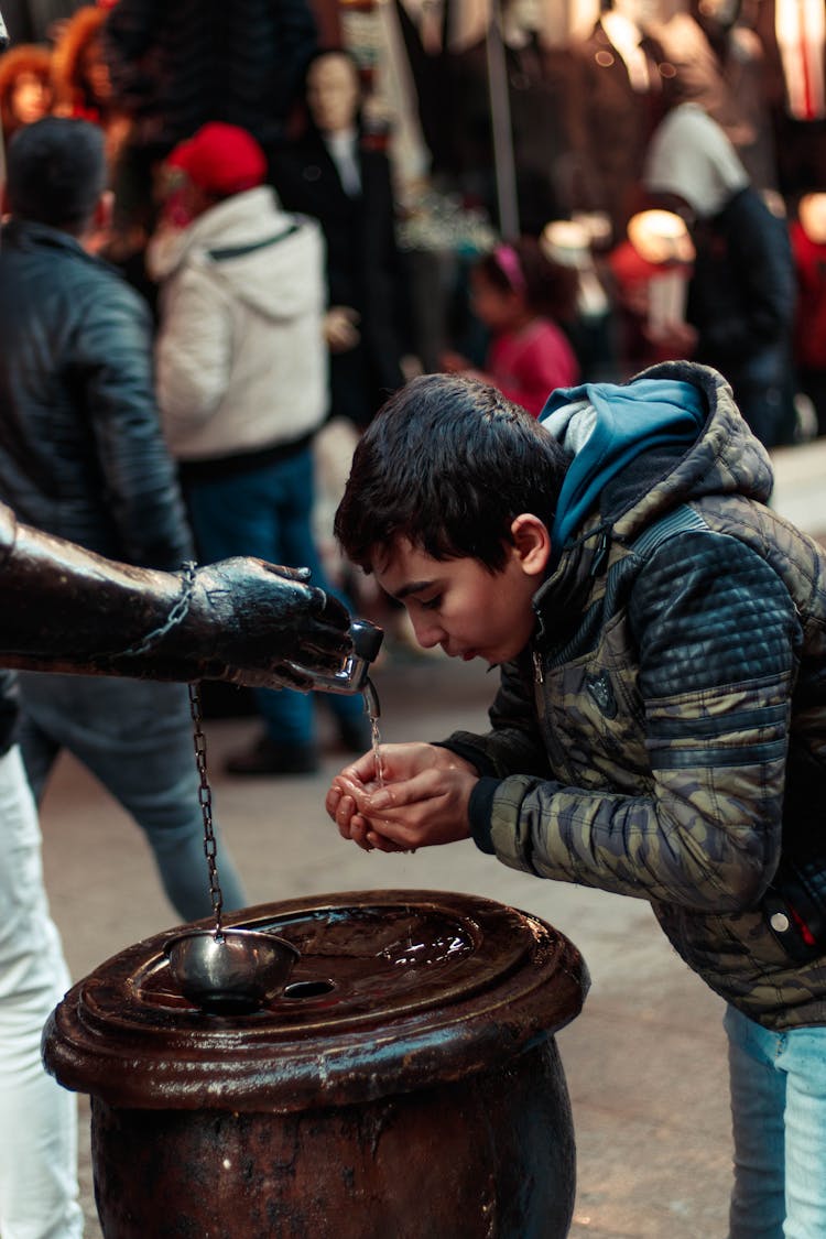 Boy Drinking Water On A Fountain