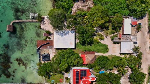 Free Aerial shot of vibrant buildings amidst lush greenery by Bacalar Lagoon, Quintana Roo. Stock Photo