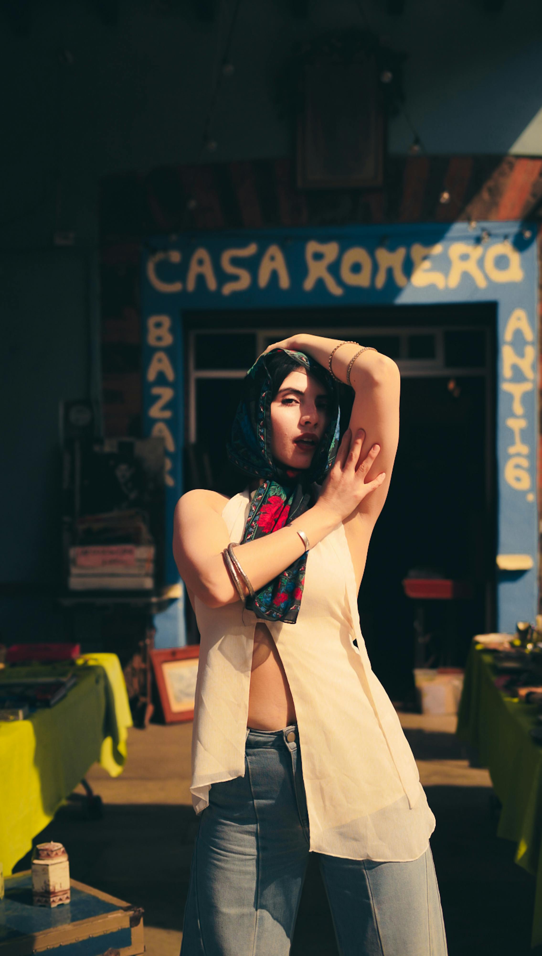 Kostenlos Eine modisch gekleidete Frau posiert selbstbewusst vor dem Casa Romero und präsentiert einen lebendigen Streetstyle. Stock-Foto