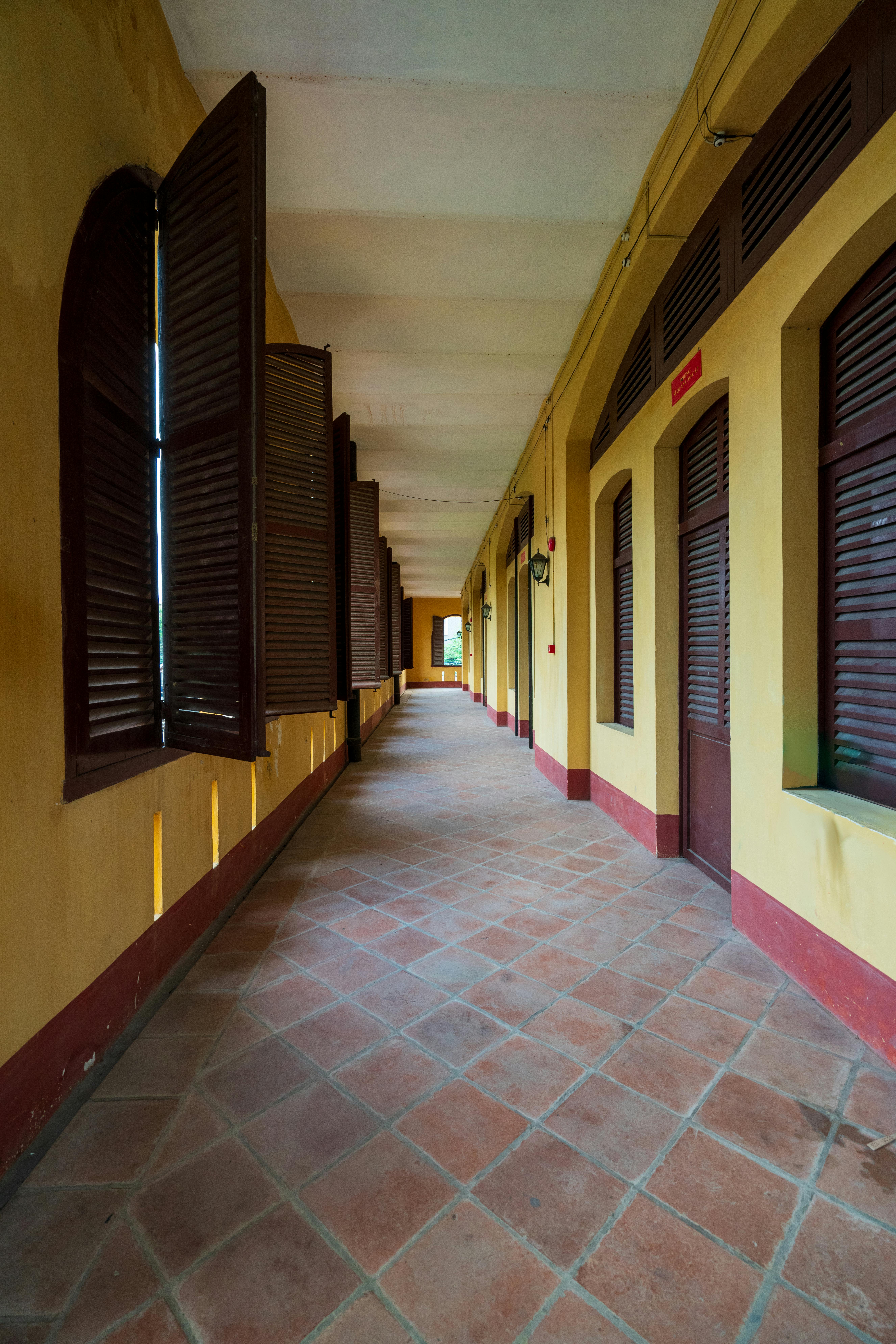 Ilmainen Rauhallinen käytävä terrakottalaatoilla ja avoimilla puisilla ikkunaluukuilla luo nostalgisen tunnelman. Kuvapankkikuva