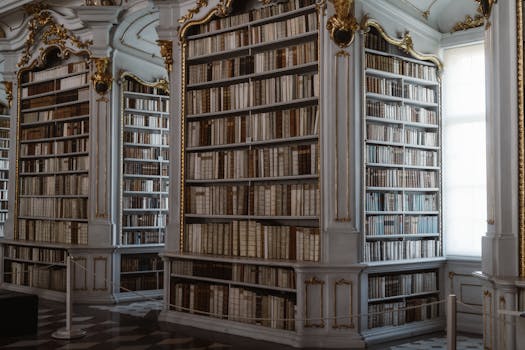 An opulent library featuring classical architecture and ornate woodwork with a vast collection of decorative books.