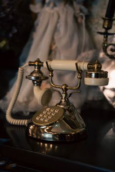 Vintage rotary telephone with gold accents and a classic corded receiver, capturing the essence of retro communication.