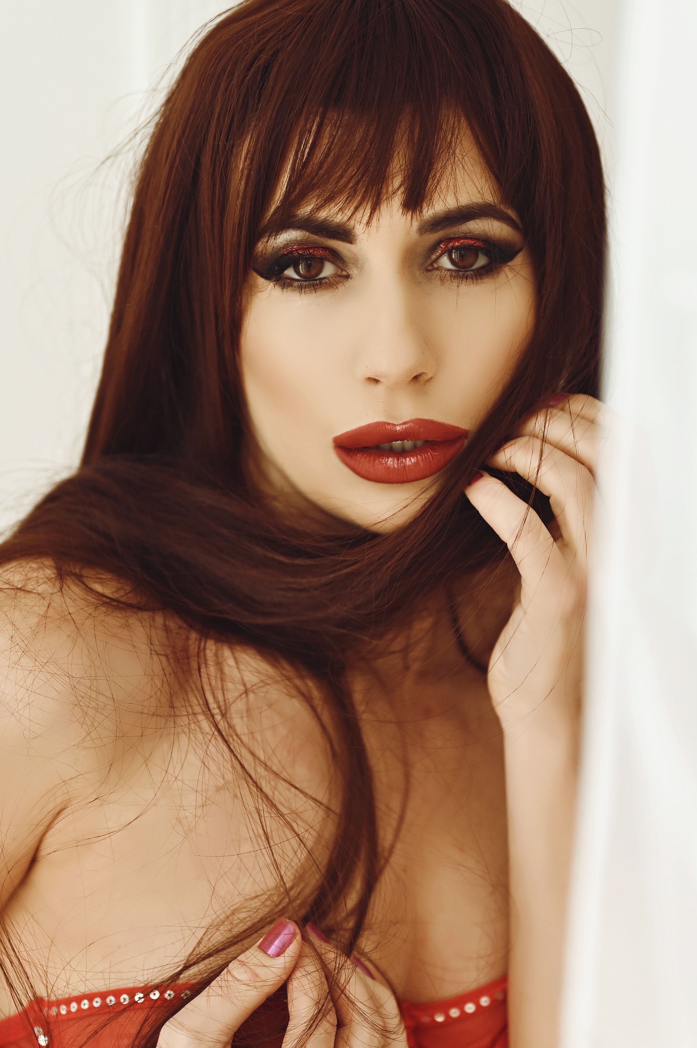 Close-up portrait of a woman with striking makeup and long brown hair, creating an elegant and captivating look.