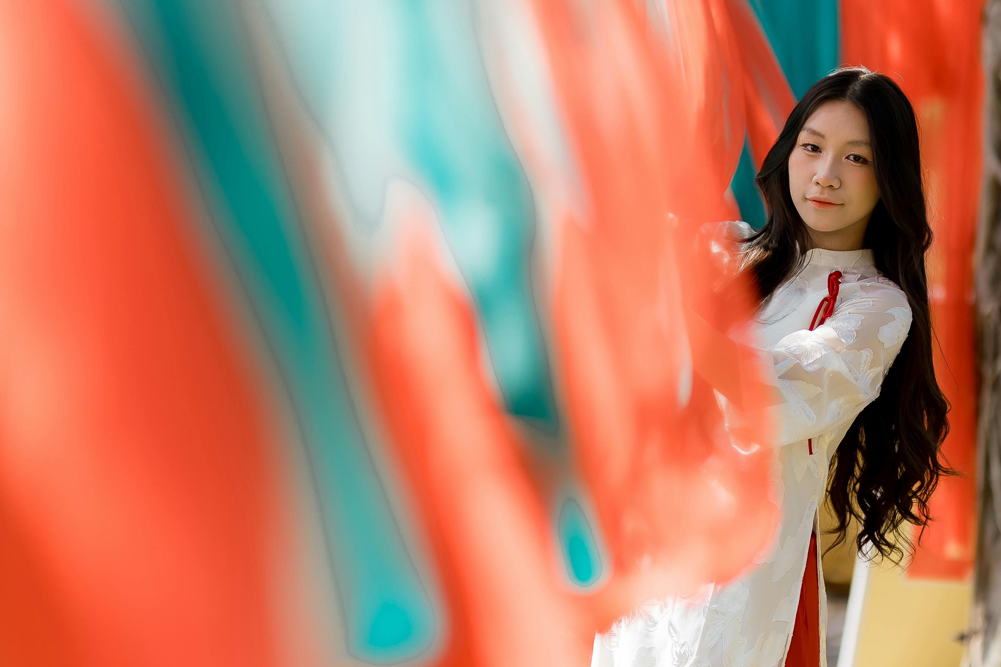 Free A woman in traditional attire stands amidst colorful flags, creating a vibrant and cultural scene. Stock Photo