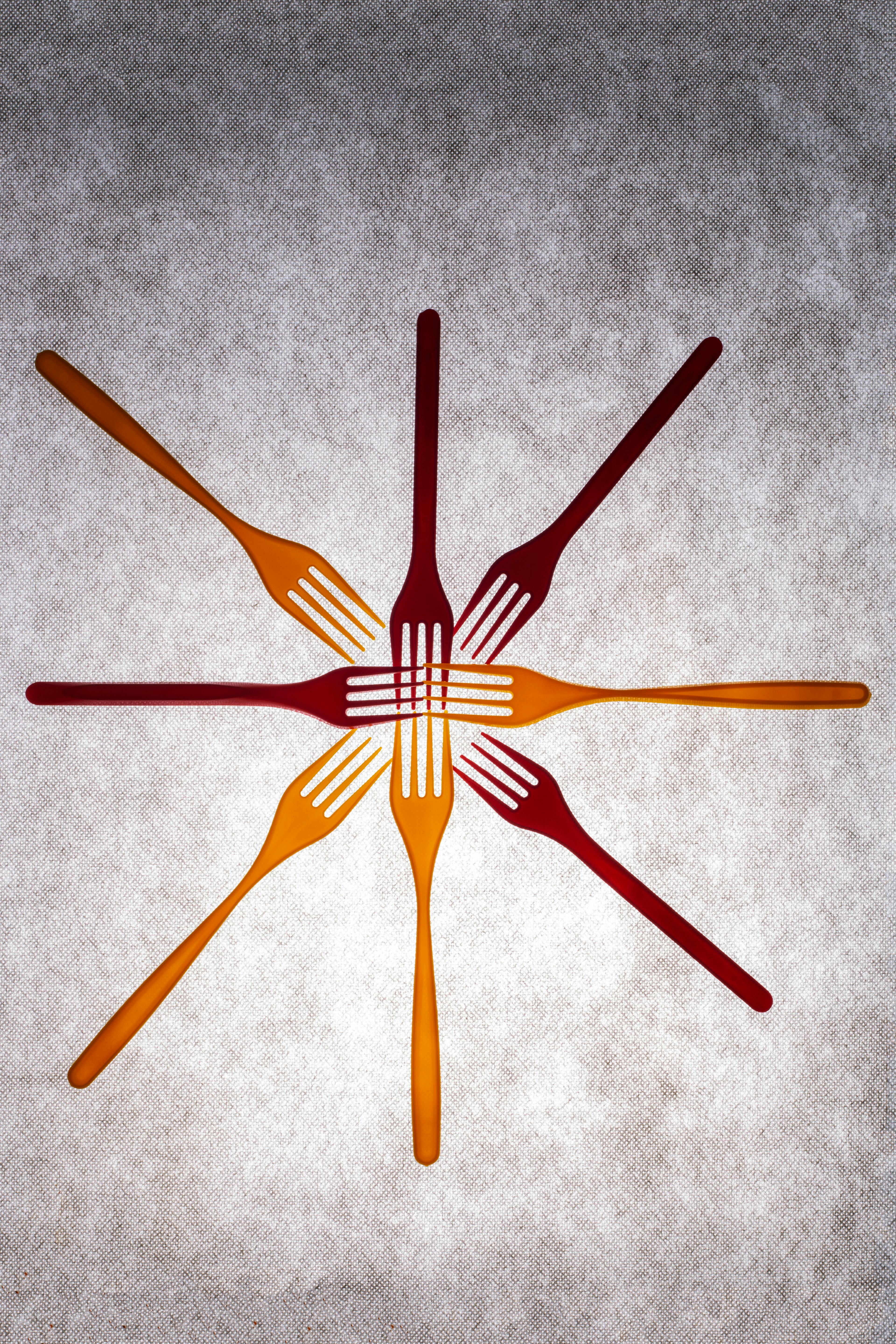Free Colorful forks arranged in a starburst pattern on a textured surface. Stock Photo