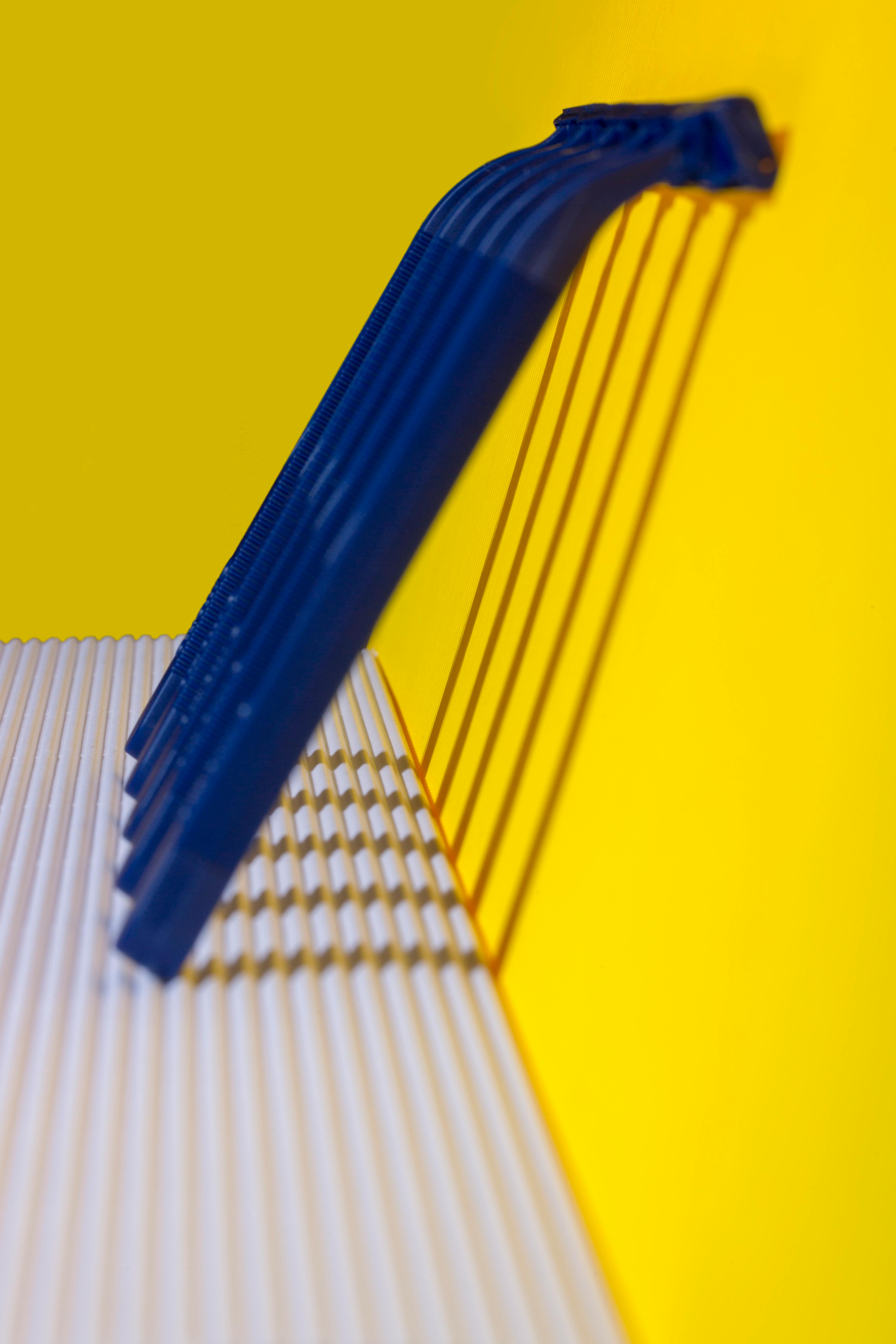 bezplatná Minimalistické abstraktní umělecké dílo s výraznými žlutými a modrými barvami vrhajícími stíny. Základová fotografie