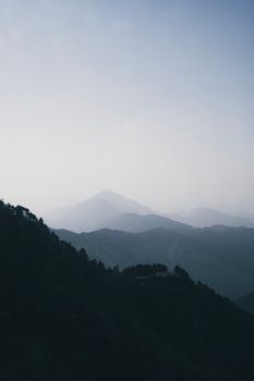 Tranquil mountain landscape with a misty foreground, perfect for nature and travel themes.