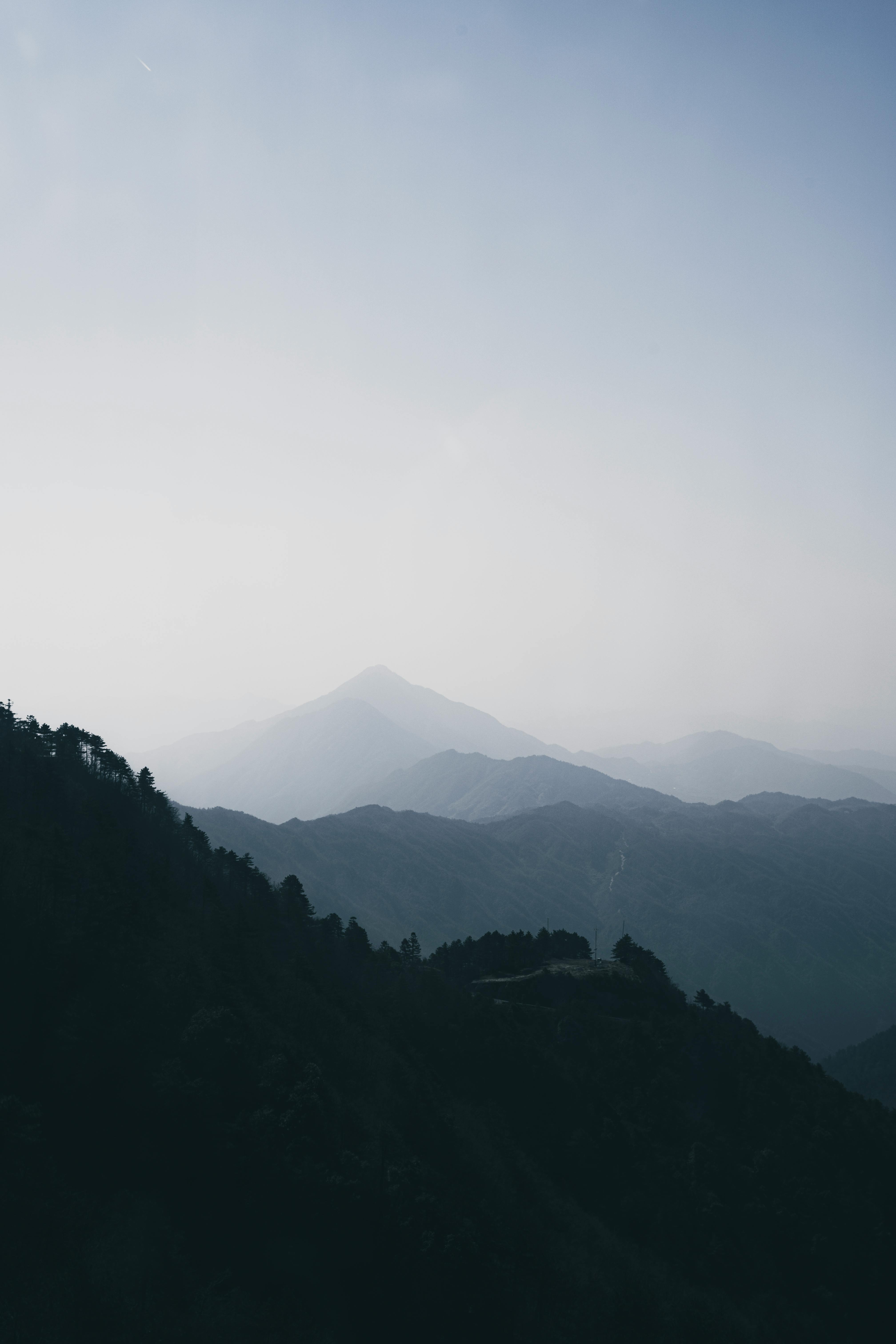 Free Tranquil mountain landscape with a misty foreground, perfect for nature and travel themes. Stock Photo