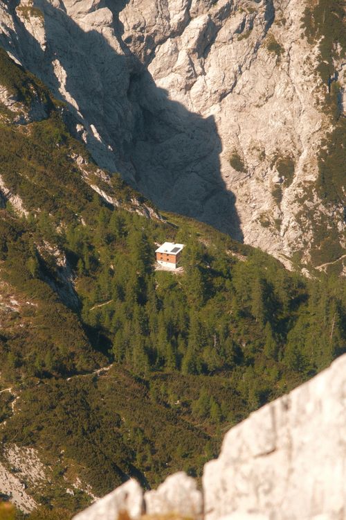 Free Isolated cabin surrounded by majestic rocky mountains and dense forest. Stock Photo