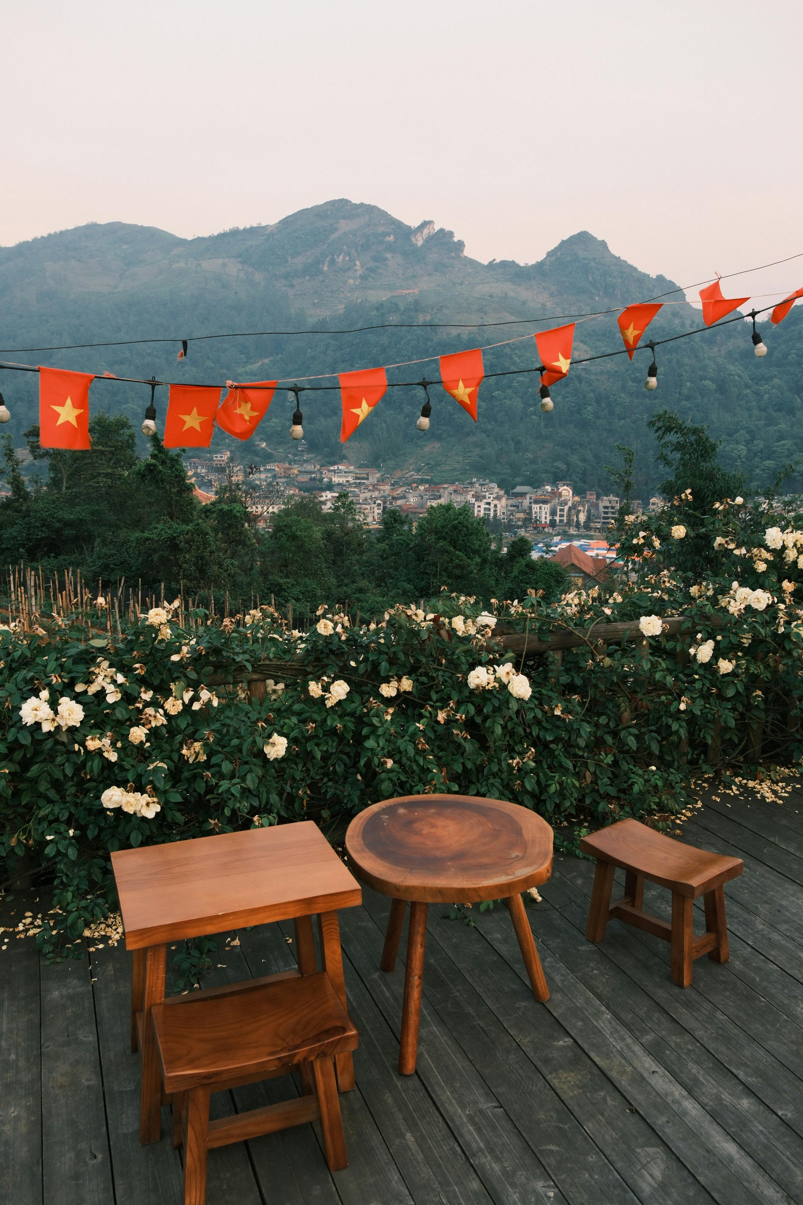 ฟรี ภาพบรรยากาศภายนอกอาคาร แสดงที่นั่งไม้พร้อมธงชาติเวียดนาม โดยมีฉากหลังเป็นภูเขา คลังภาพถ่าย